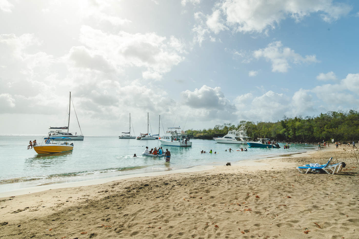 A line of anchored boats and people swimming in the bay in front of Cochon beach. 