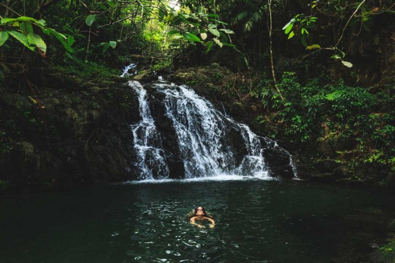 Woman swimming at Antelope Falls one of the best Belize waterfalls