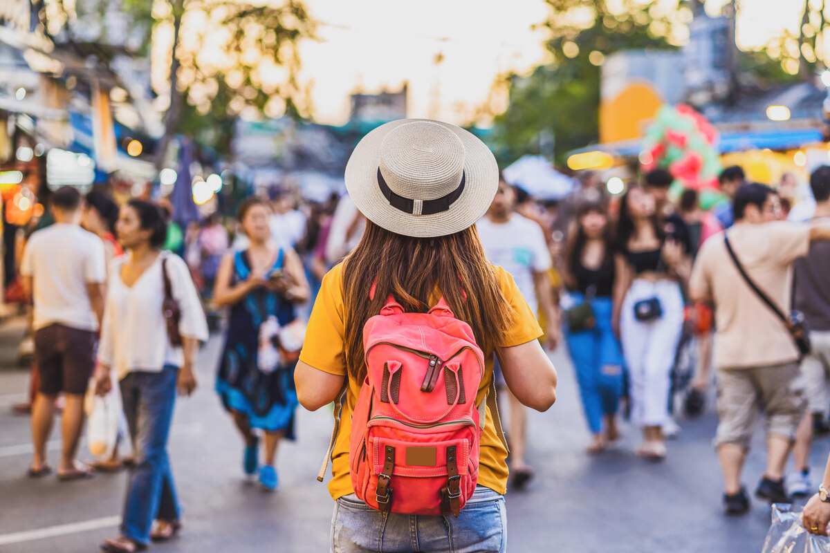Woman with backpack at market Thailand packing list