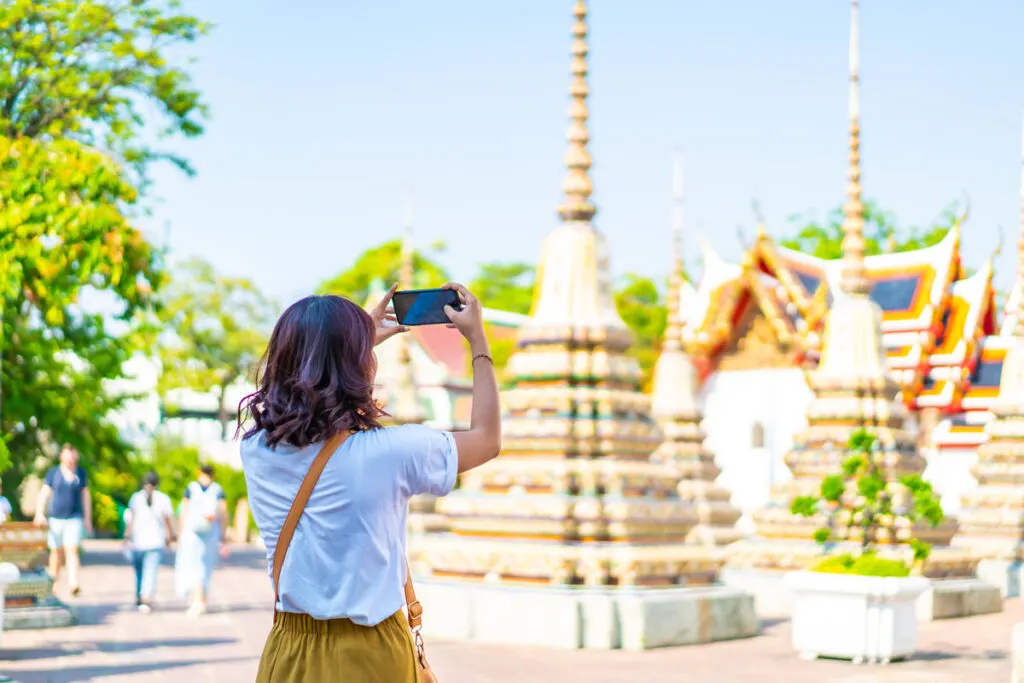 Woman taking photo of temple Thailand packing list