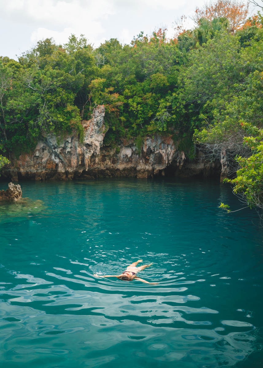 Me swimming in Blue Hole, Bermuda surrounded by a cliff and greenery