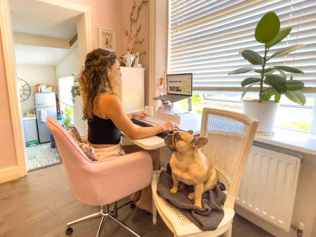 Me at a desk in London being a digital nomad with a dog