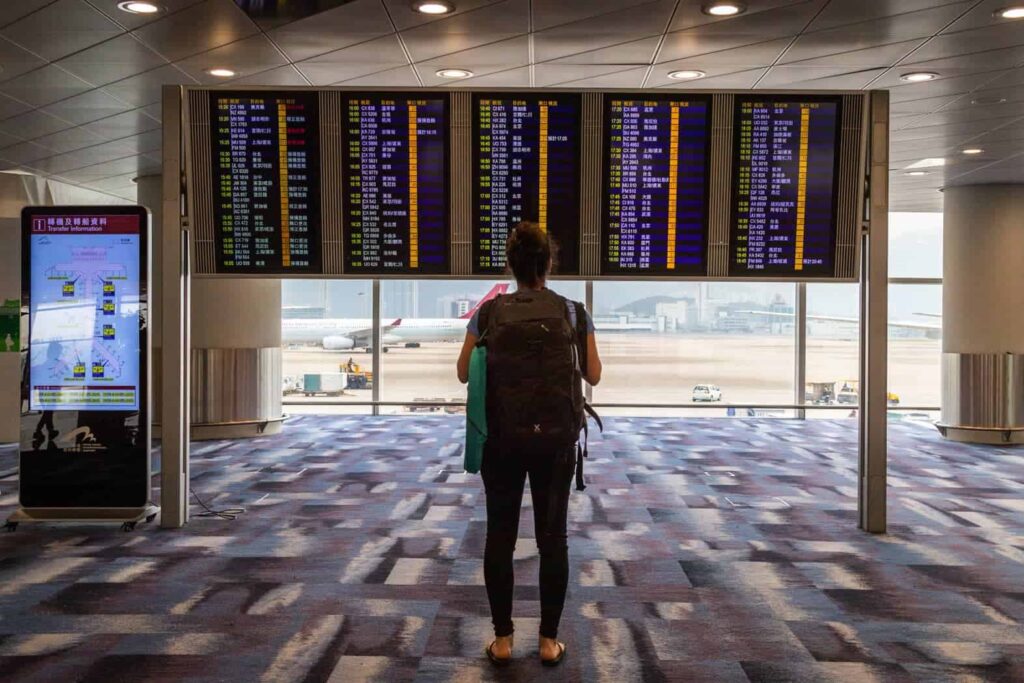 Looking at flights on an airport board.