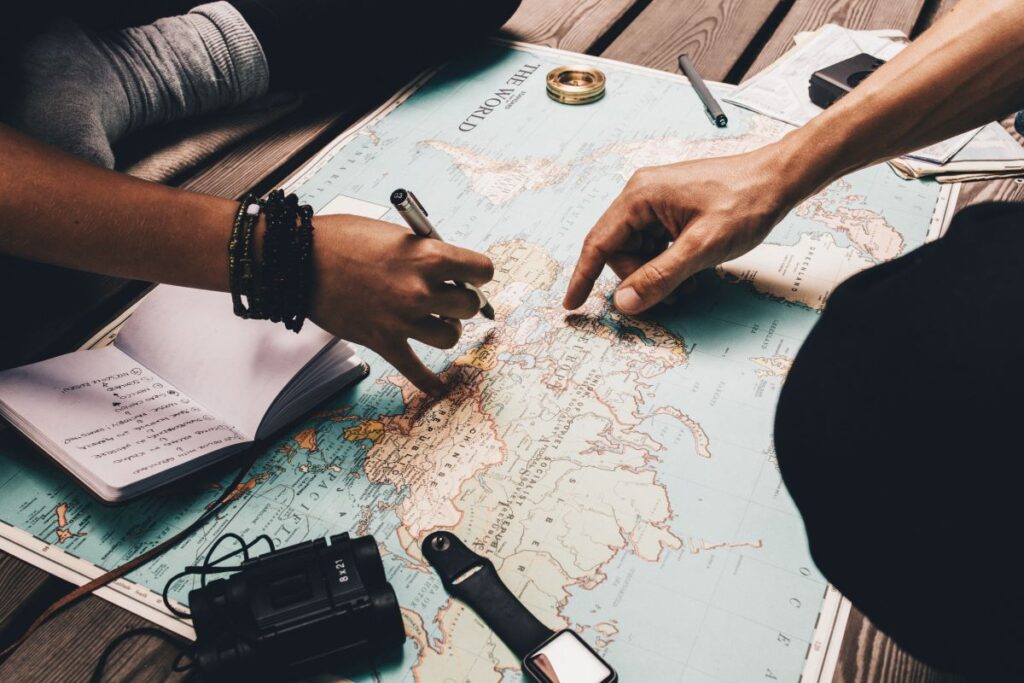 People planning a trip with a map so they can digital nomad