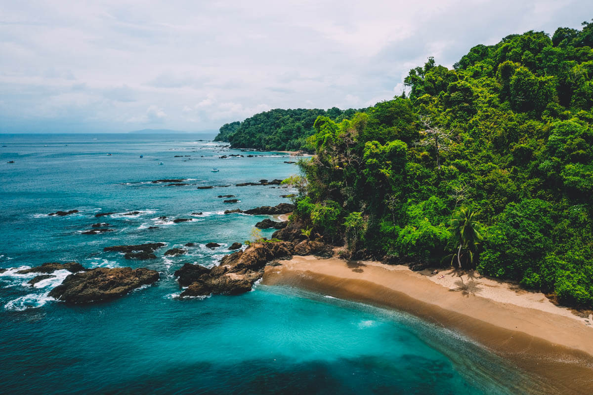 An aerial shot of a golden beach and blue ocean water at Caño Island in Costa Rica.