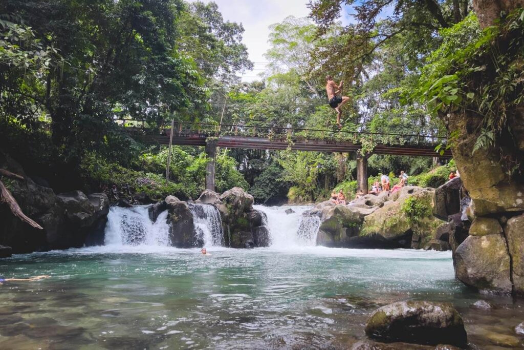 Man hanging from the El Salto rope swing in La Fortuna.