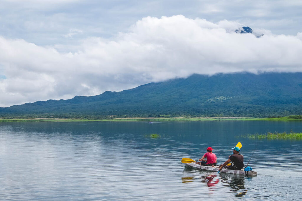 Two men kayaking on Arenal Lake.