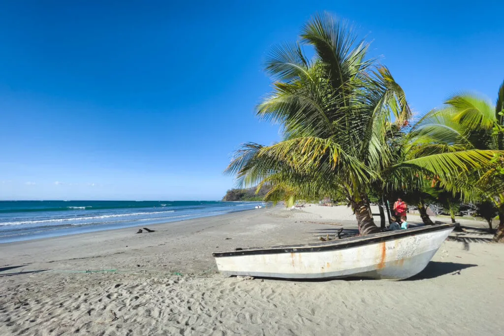 A small boat and palm trees on Samara Beach.