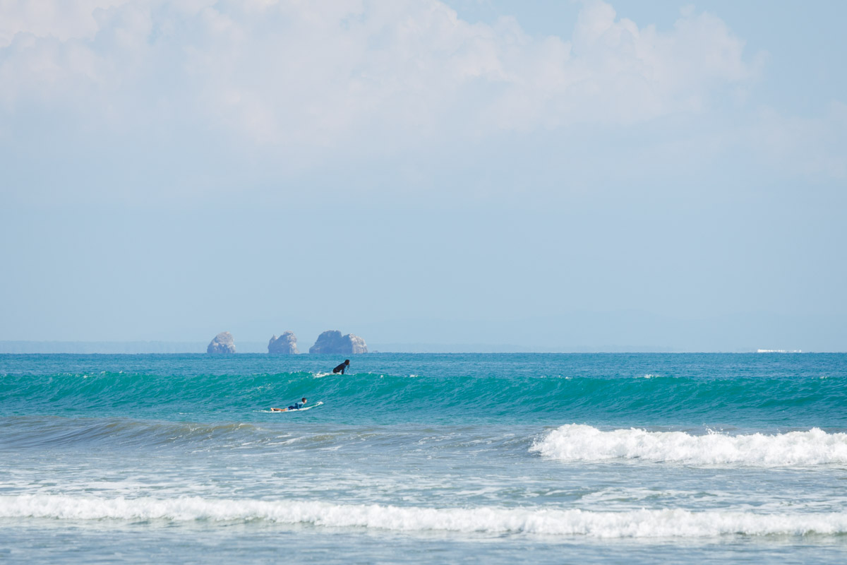 Surfers on the waves in Marino Ballena National Park.