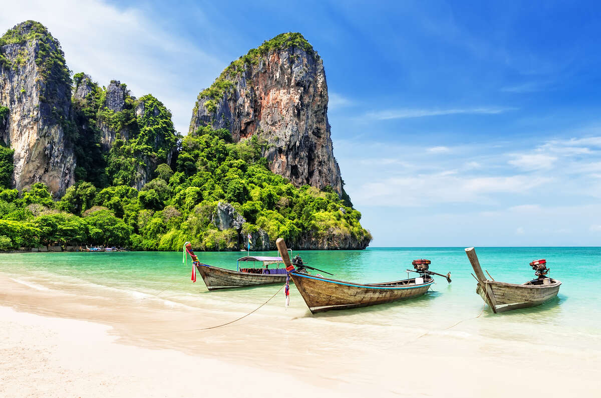 Krabi, Thailand with boats in the water and mountains in the back visited on a Southeast backpacking trip