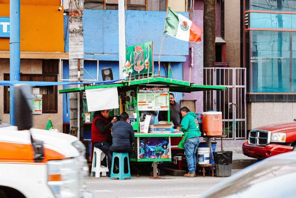 Customers surrounding a Mexican street food stall in Ensenada.