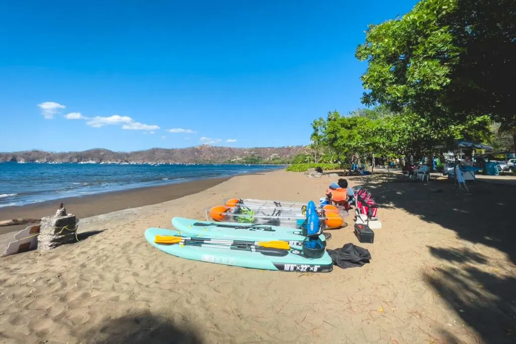 Paddle boards and transparent kayaks on Playa del Coco Beach in Costa Rica.