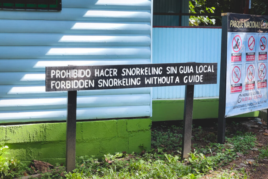 The park sign stating that snorkeling is forbidden in the national park without a guide.