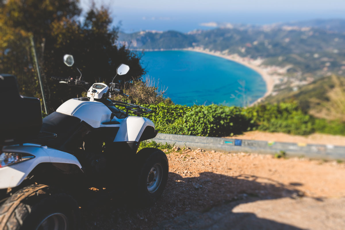 A white ATV parked at a viewpoint that looks over the Greek Island of Corfu - a great experience in Europe.