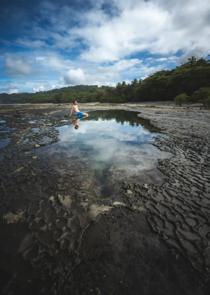 A backpacker sits in the Mal Pais tide pools.