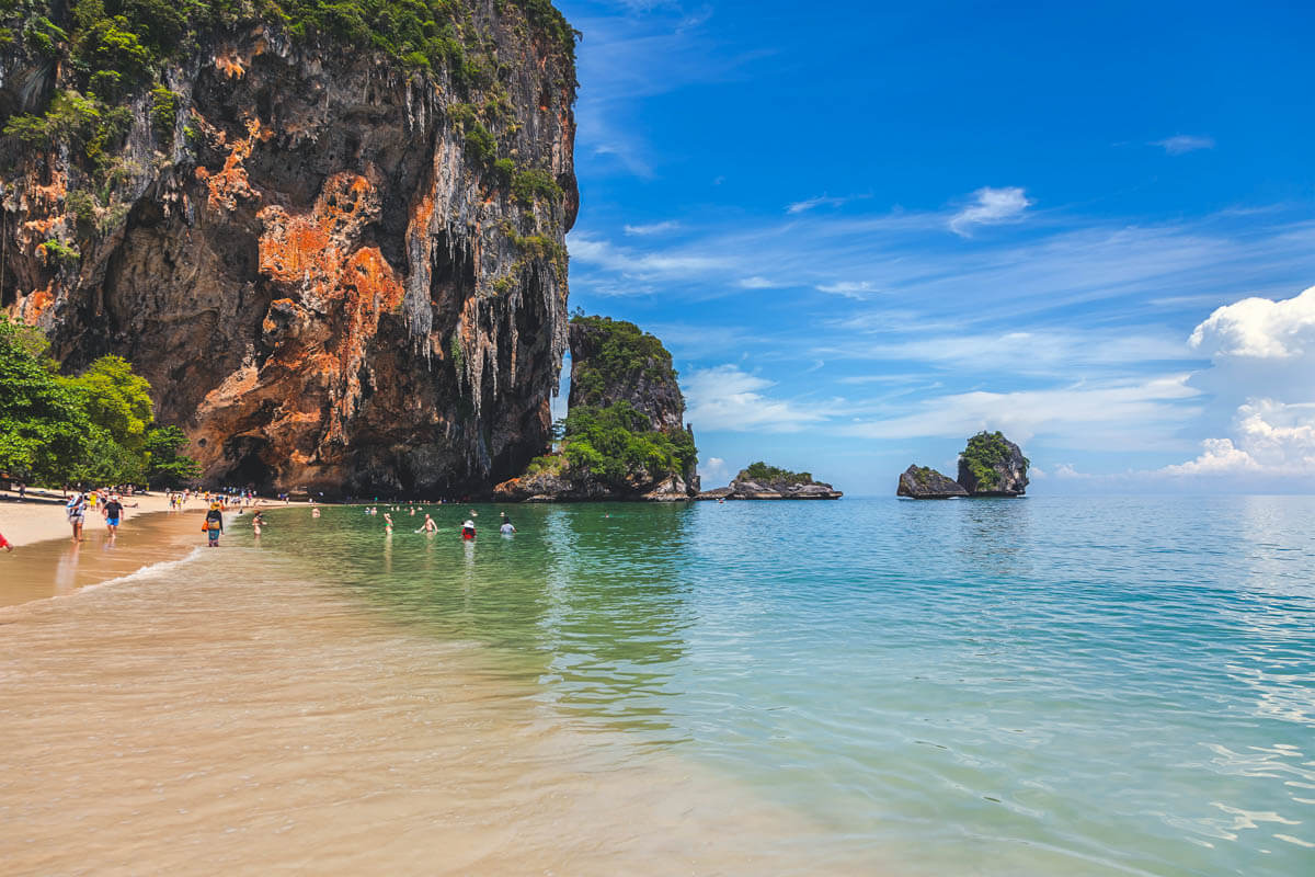 Tourists swimming in the amazing blue waters of Phra Nang Beach on Railay Island. Tourists swimming in the amazing blue waters of Phra Nang Beach on Railay Island.