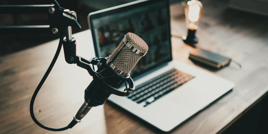Podcast set up on a desk with computer and mic