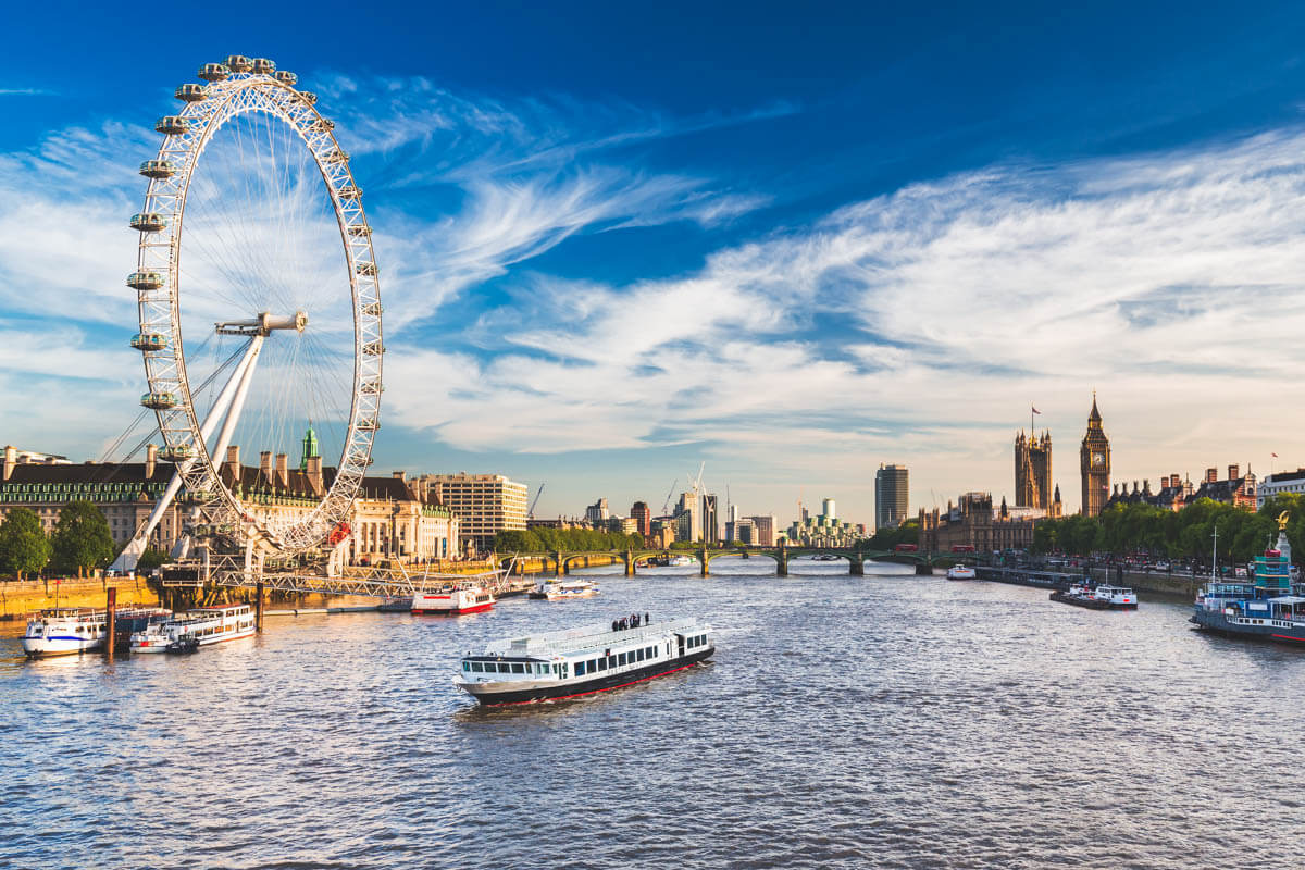 An Uber boat navigating the River Thames around the London Eye at Southbank with Westminster Parliament and Big Ben in the background - all great things to do in Europe.