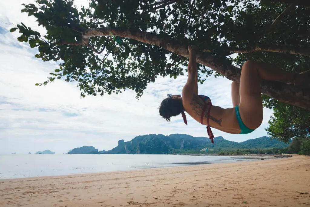 Nina hanging from a tree on Ao Nam Mao Beach, considered a great Krabi beach in Thailand.