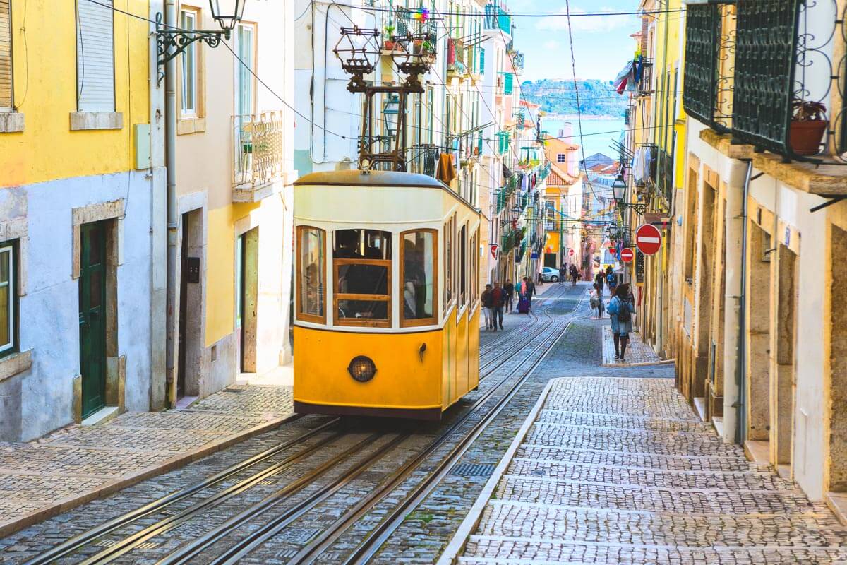 The classic yellow Bica Tram in Lisbon, Portugal, making its way up the hill.