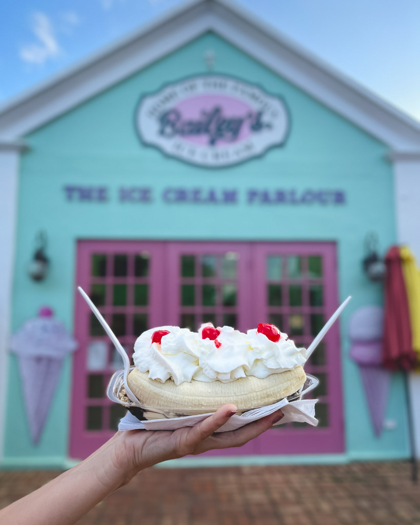 I'm holding up a banana split outside Bailey's Bay Ice Cream Parlour in Bermuda.
