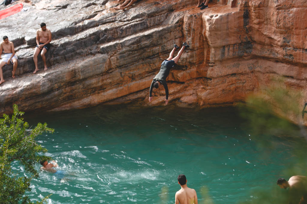 Cliff jumper mid air about to splash into the river at Paradise valley.