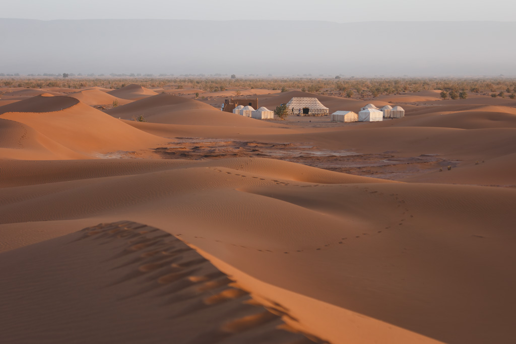 Shot of footsteps along the sand dunes that lead to a luxury desert camp in the Sahara.