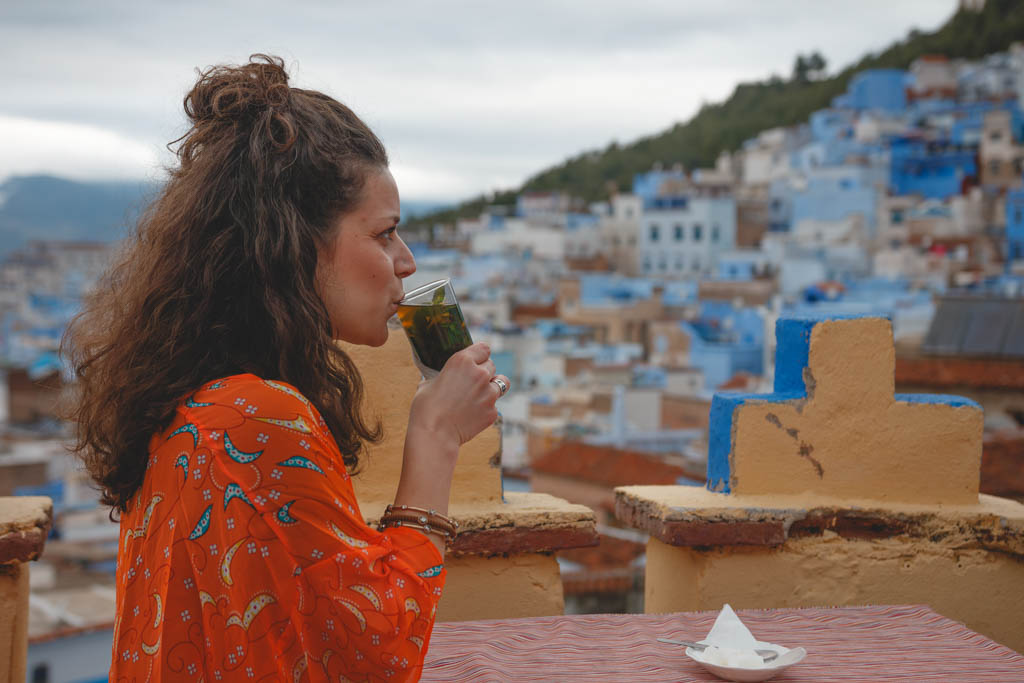 Nina drinking tea on a rooftop at the blue city in Morocco.