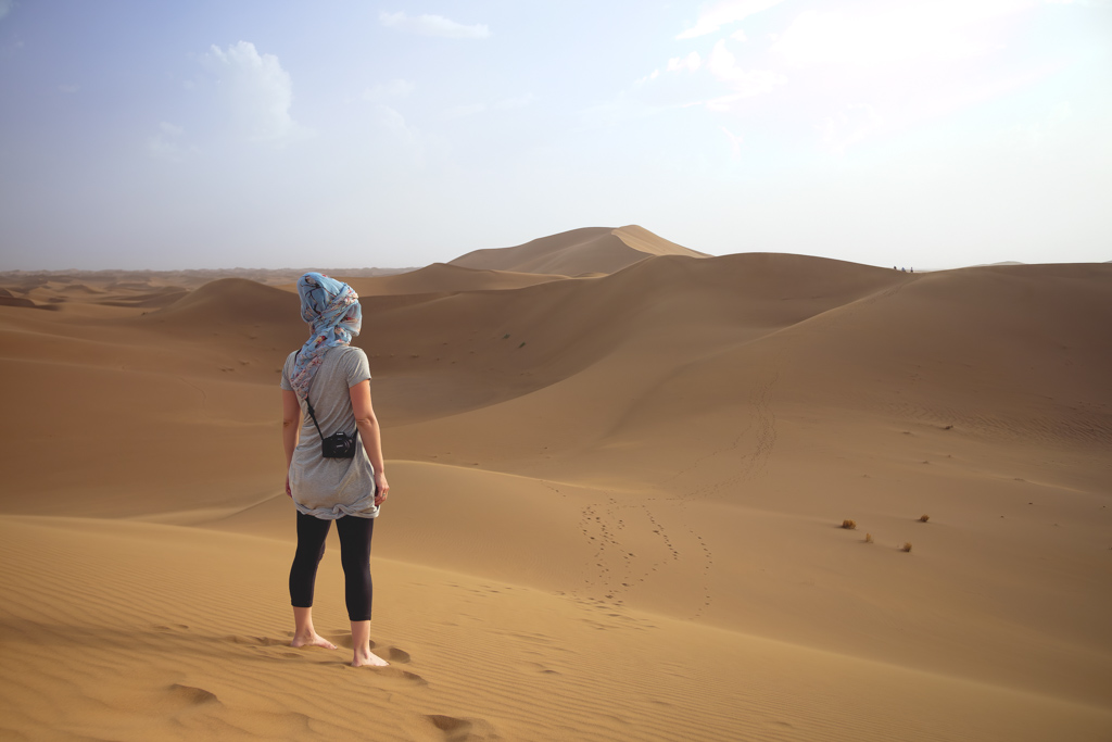 Nina looking out into the endless desert of Erg Chigaga in Morocco.