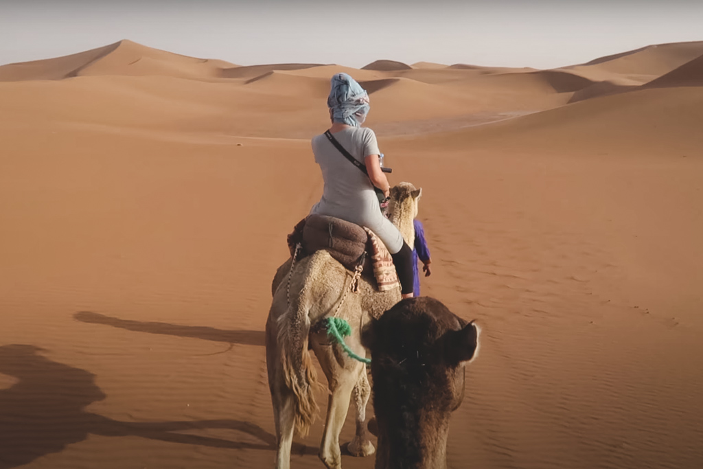 Nina riding a camel in the Sahara desert in Morocco.