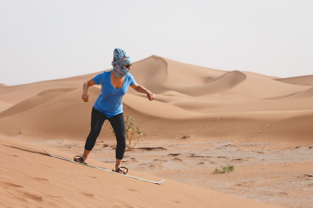 Nina sandboarding down a sand dune in Morocco.