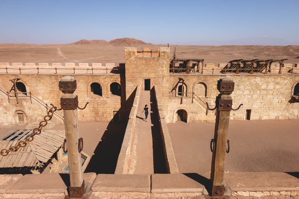 Nina walking across a bridge at a castle film set in Morocco. 