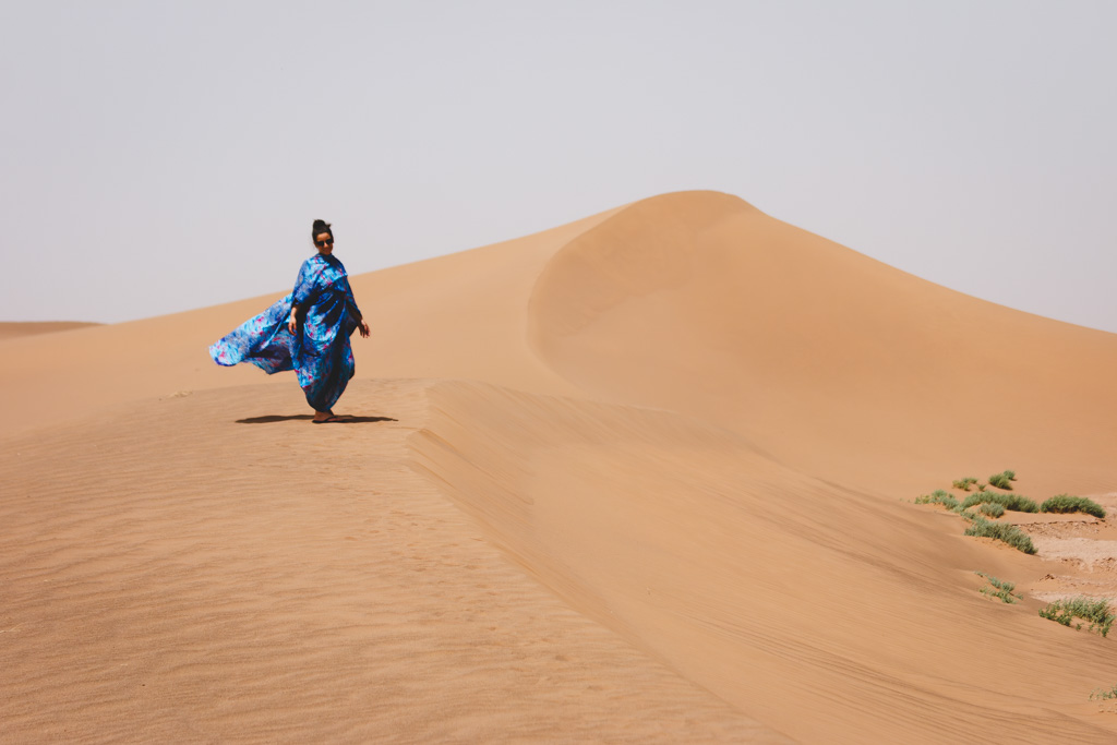 Nina wearing a traditional Melhfa on some sand dunes in Morocco.