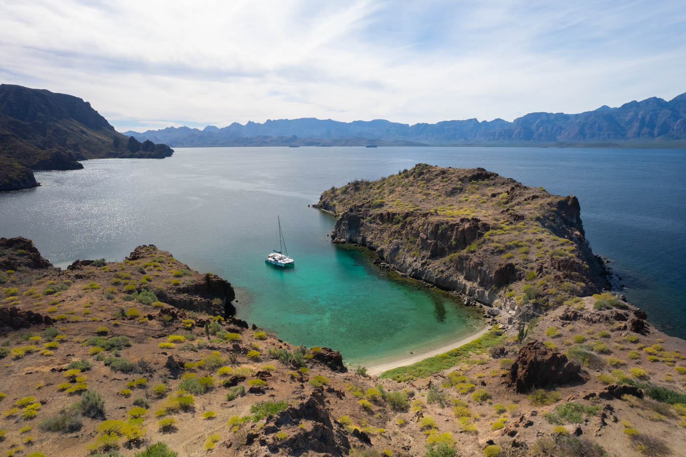 Catamaran moored off the coast of Playa Lune de Miel in blue ocean waters of Baja Sur. Catamaran moored off the coast of Playa Lune de Miel in blue ocean waters of Baja Sur.