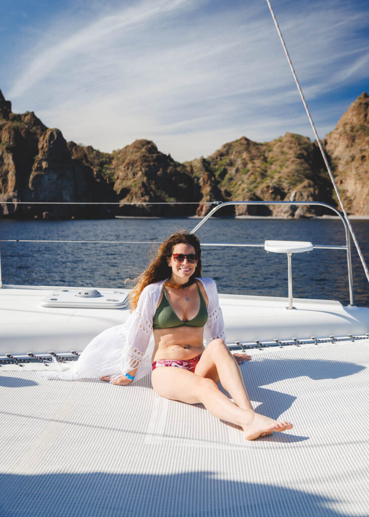 Nina sunbathing on the netting of a catamaran in Baja Sur.