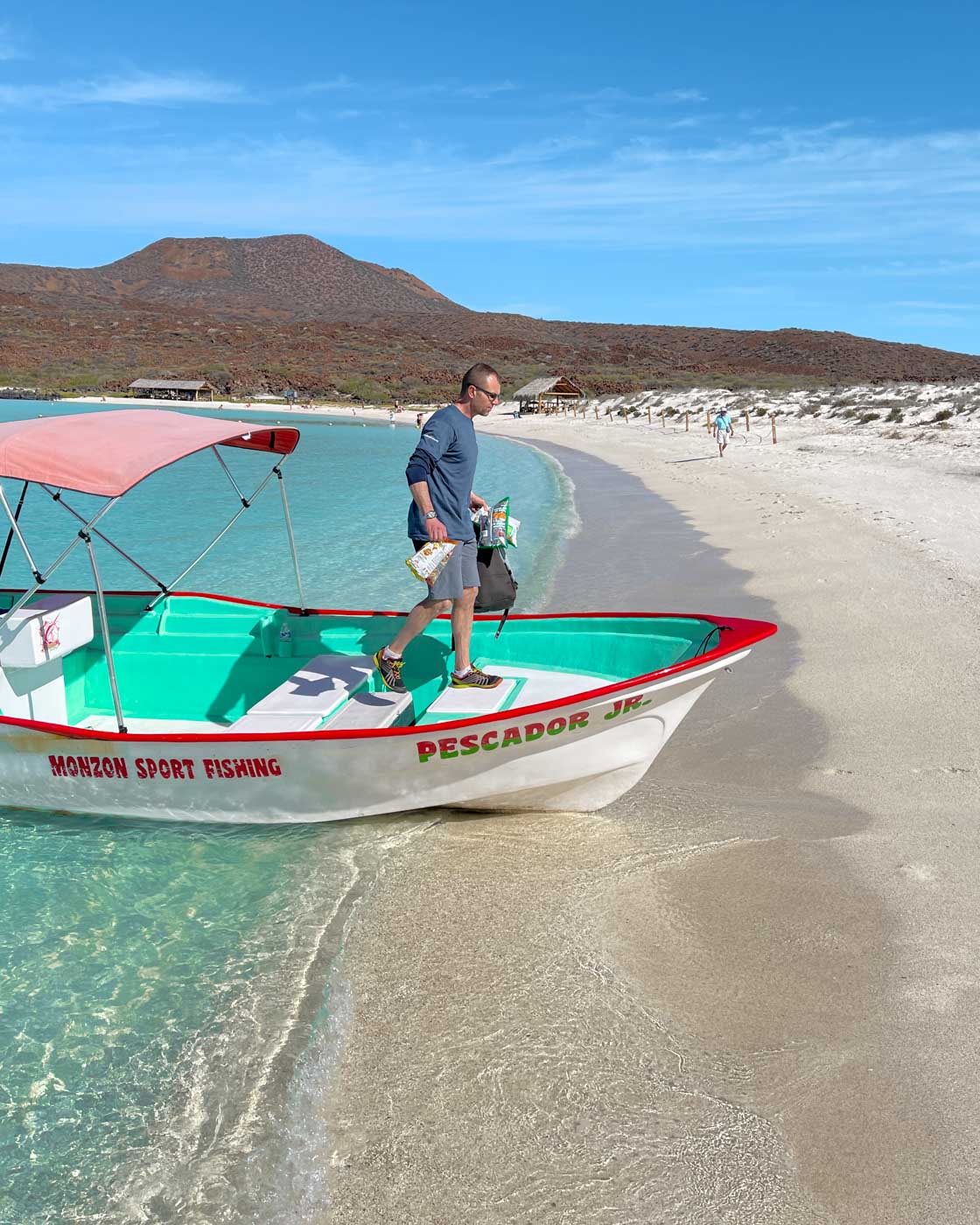 Man disembarking a fishing boat onto Playa Isla Coronado in Baja California Sur. Man disembarking a fishing boat onto Playa Isla Coronado in Baja California Sur.