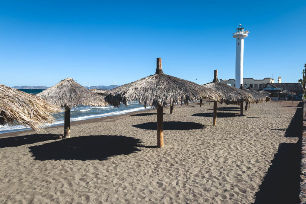 Grass umbrellas on Playa la Darsena in Loreto on a sunny day.