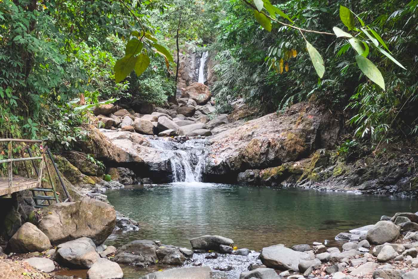 One of the swimming areas at Uvita Waterfall surrounded by trees.