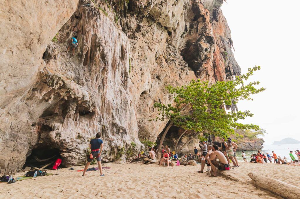Tourists watching a rock climber on the cliffs of Tonsai near Krabi.
