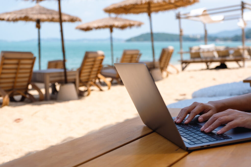 Digital nomad on a laptop on the beach