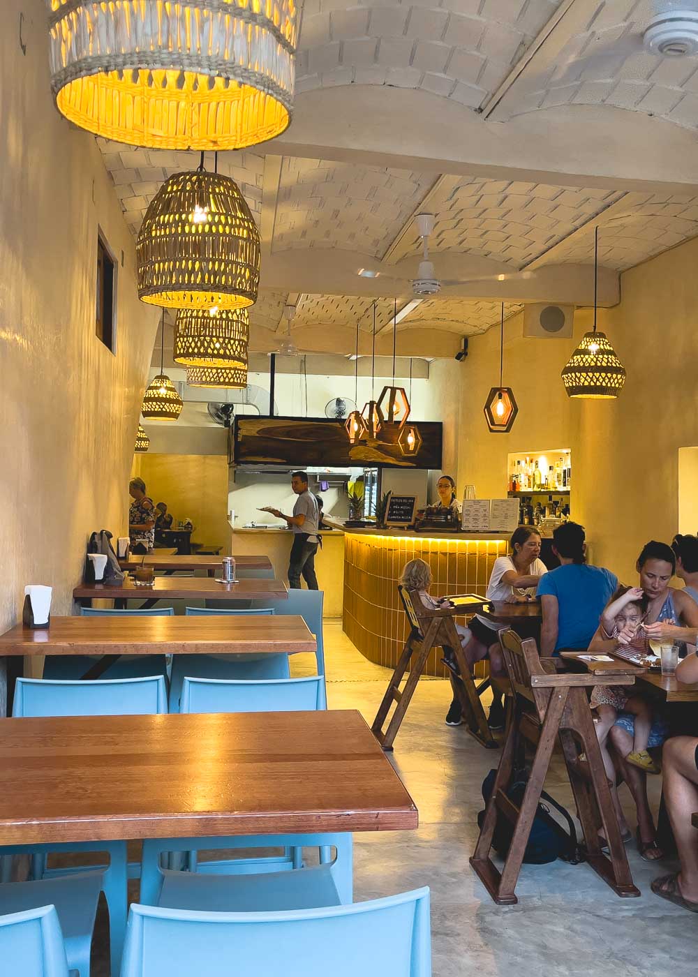 Clean interior with beautiful soft lighting with plenty of tables inside Bichos Tacos restaurant.