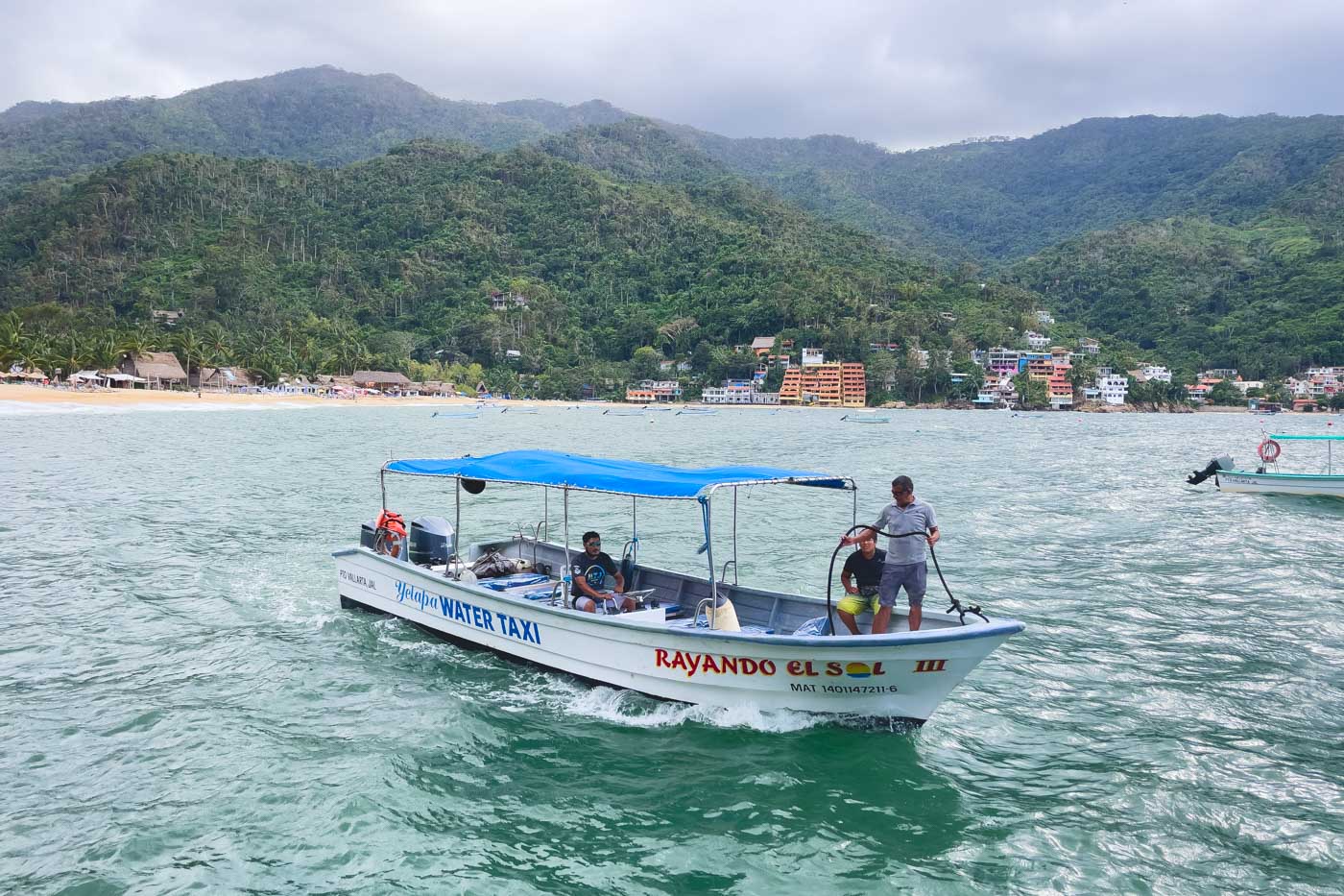 Water taxi carrying passengers amongst the mountains in Yelapa.