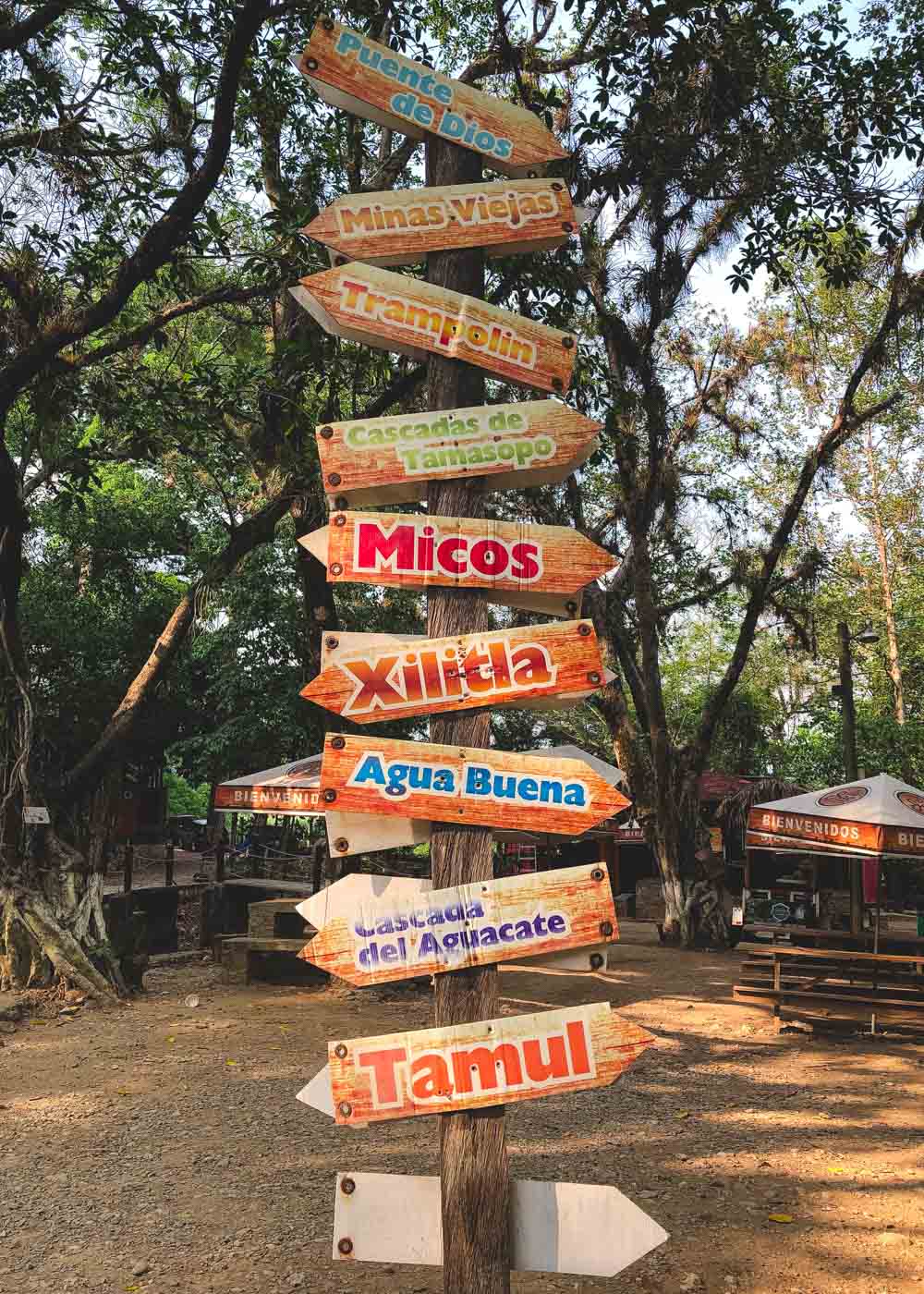 A wooden post with multiple signs pointing to different activities and locations within Huasteca Potosina.