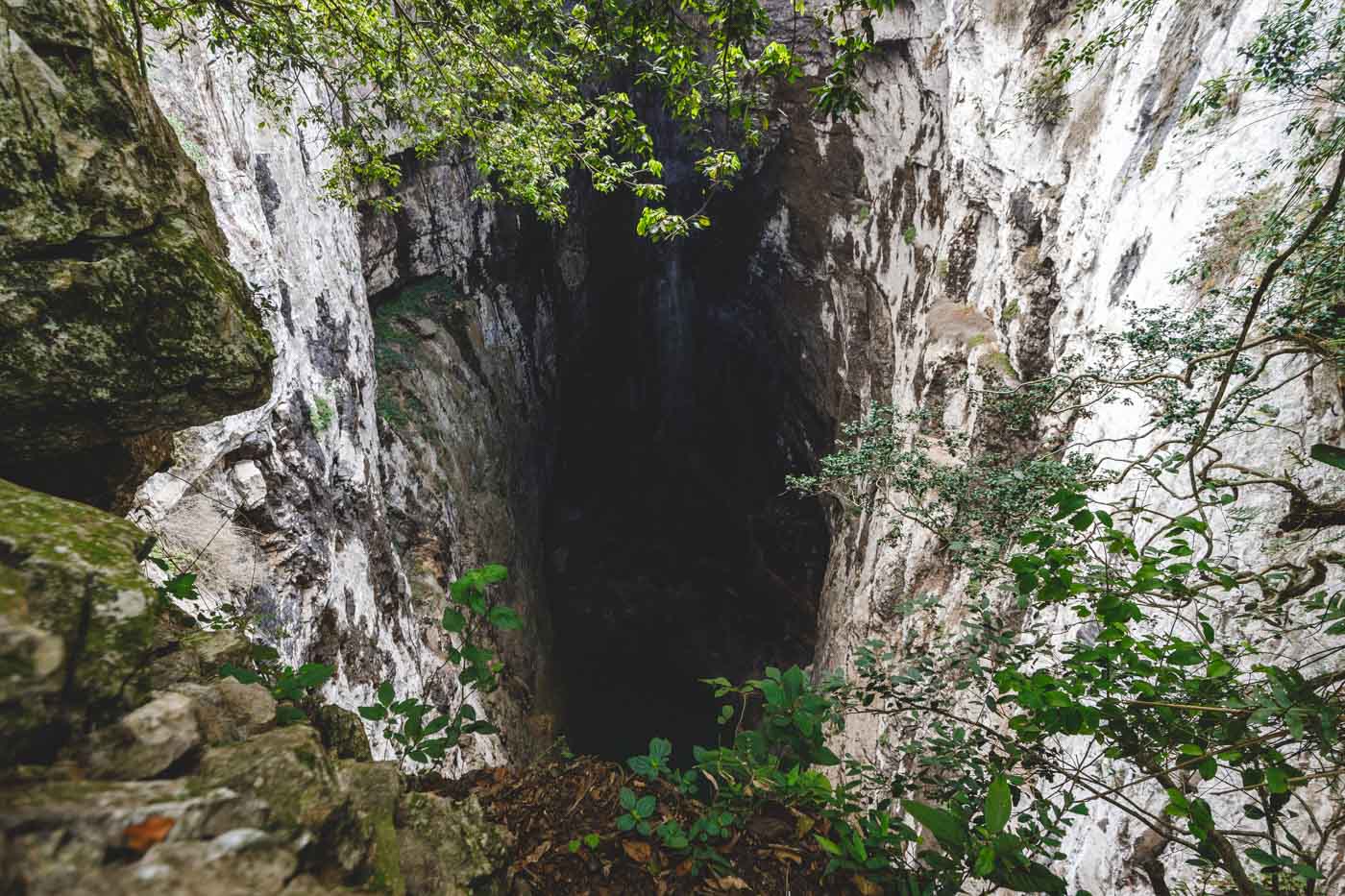 Looking over a cliff edge into the large and empty Huahua Cave.