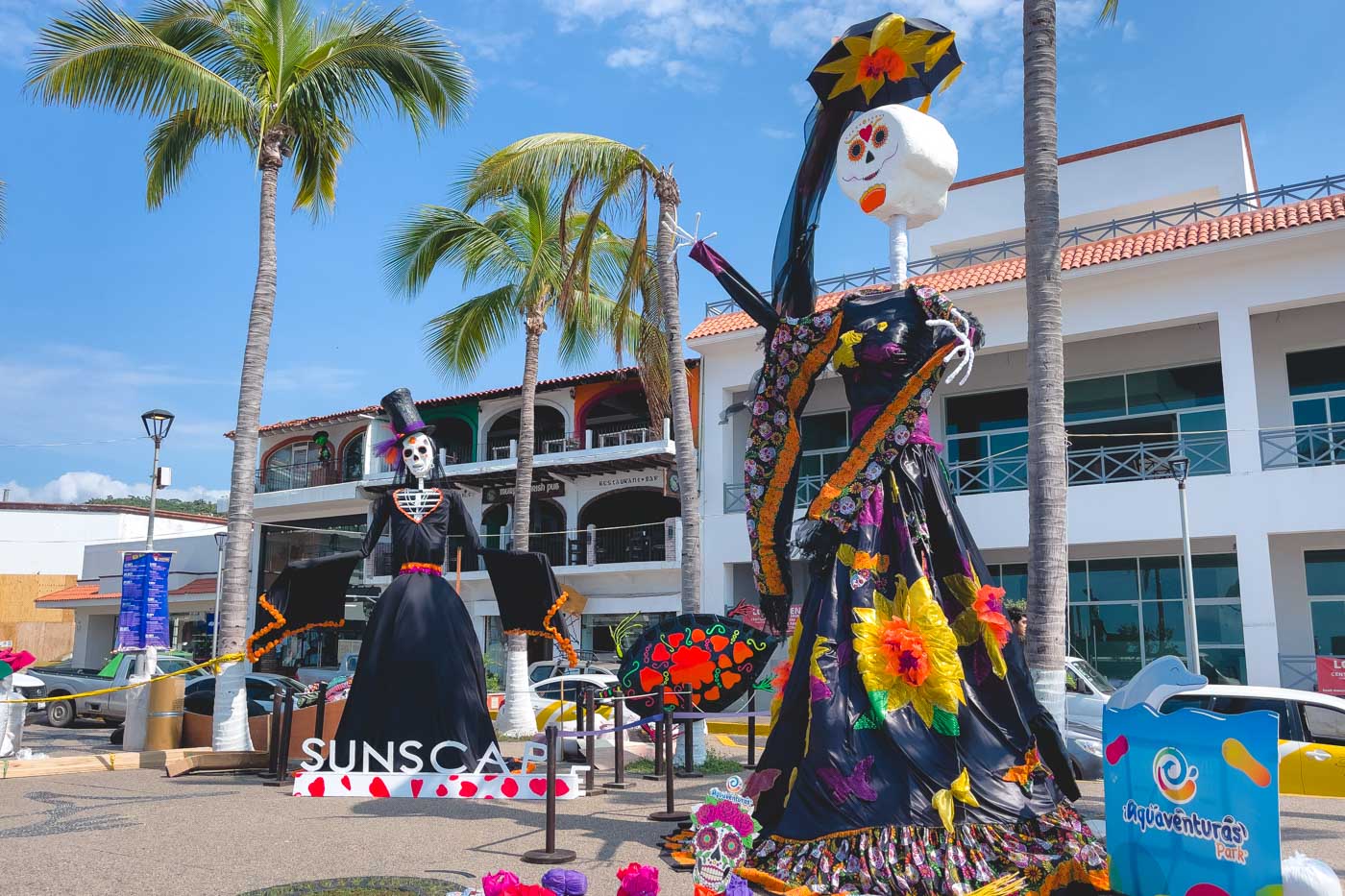 Day of the Dead themed sculptures underneath palm trees along Puerto Vallarta Malecon.
