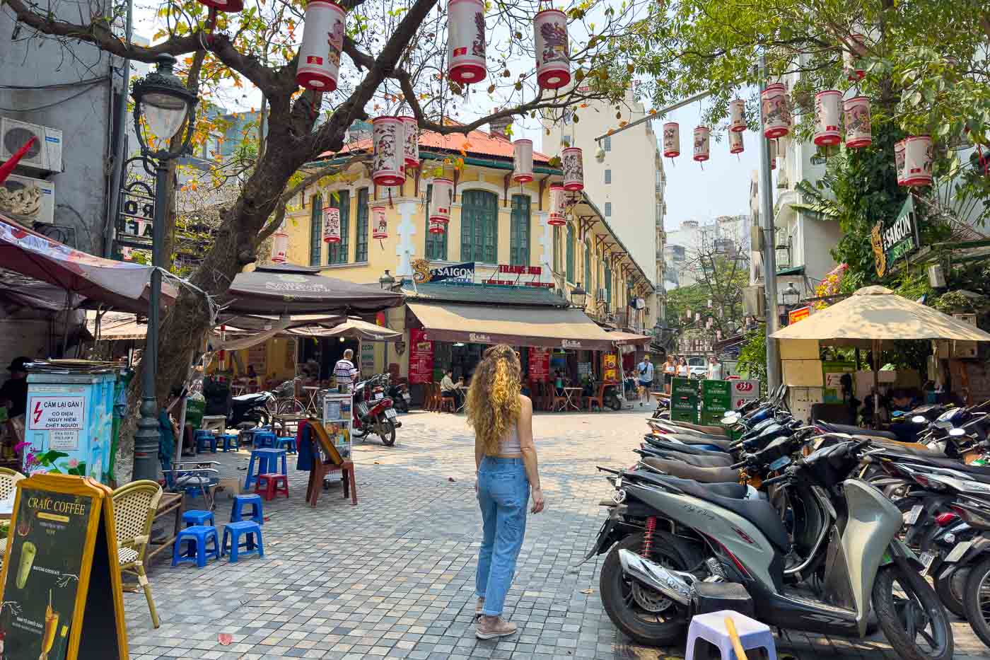 Nina standing in a cute and decorated street in Hanoi, Vietnam.