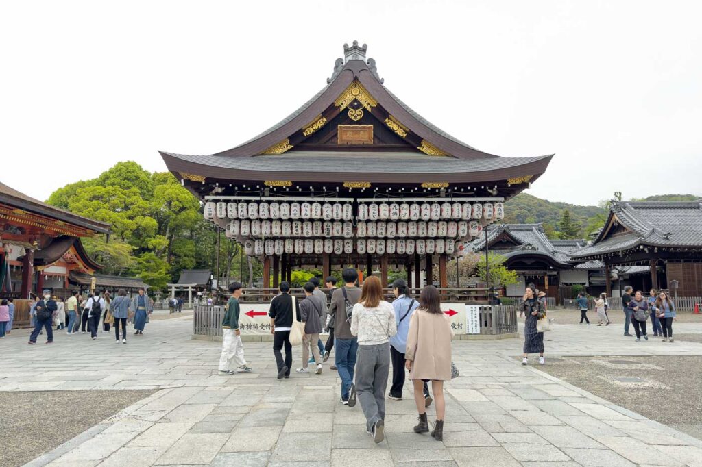 Yasaka Shrine in Kyoto with people in front of it and many white lanterns.