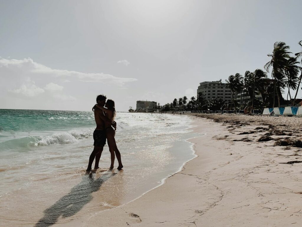 A couple shares a romantic embrace on a picturesque San Andrés beach. Perfect serene getaway.