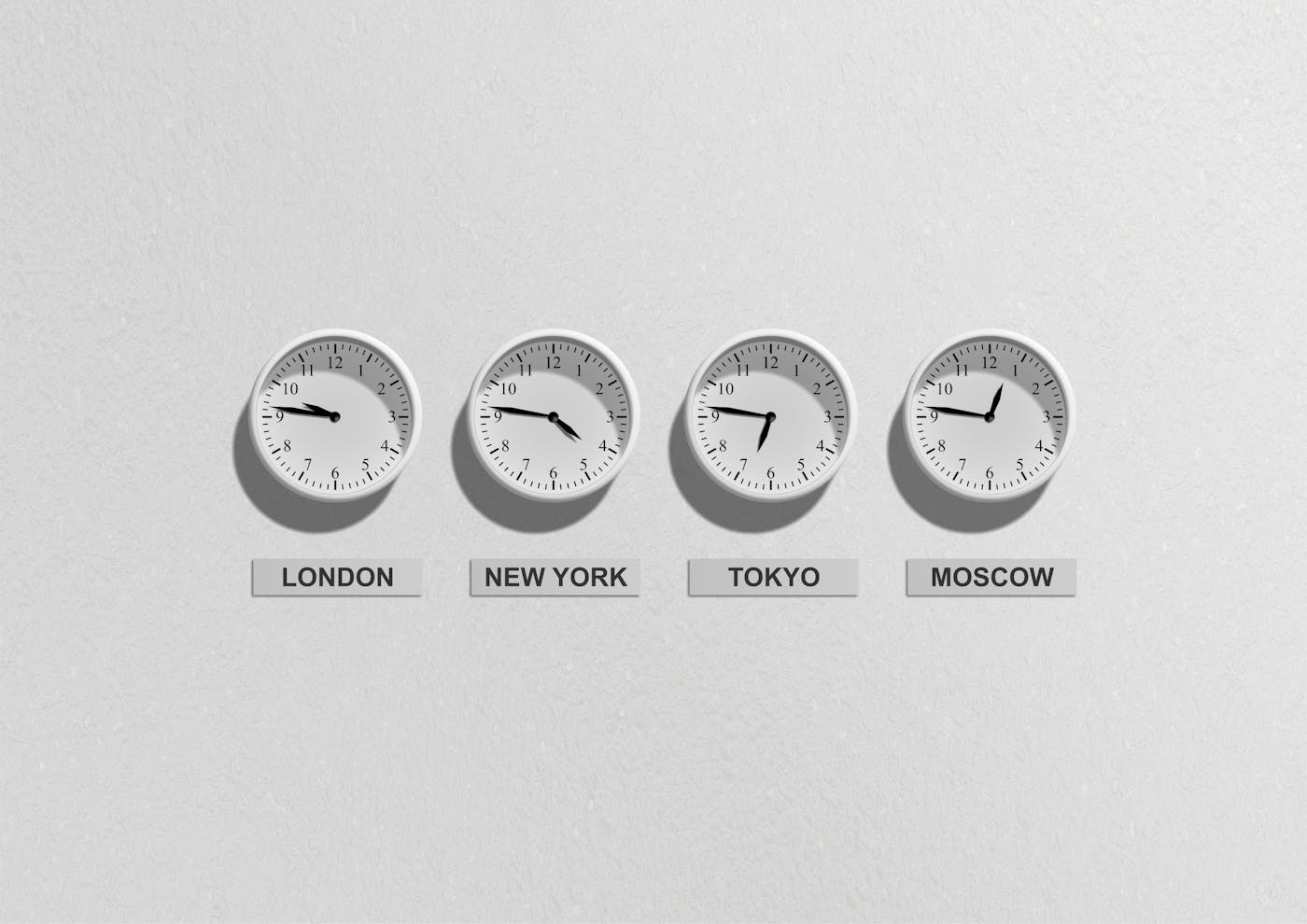 Four wall clocks showing different time zones for London, New York, Tokyo, and Moscow.