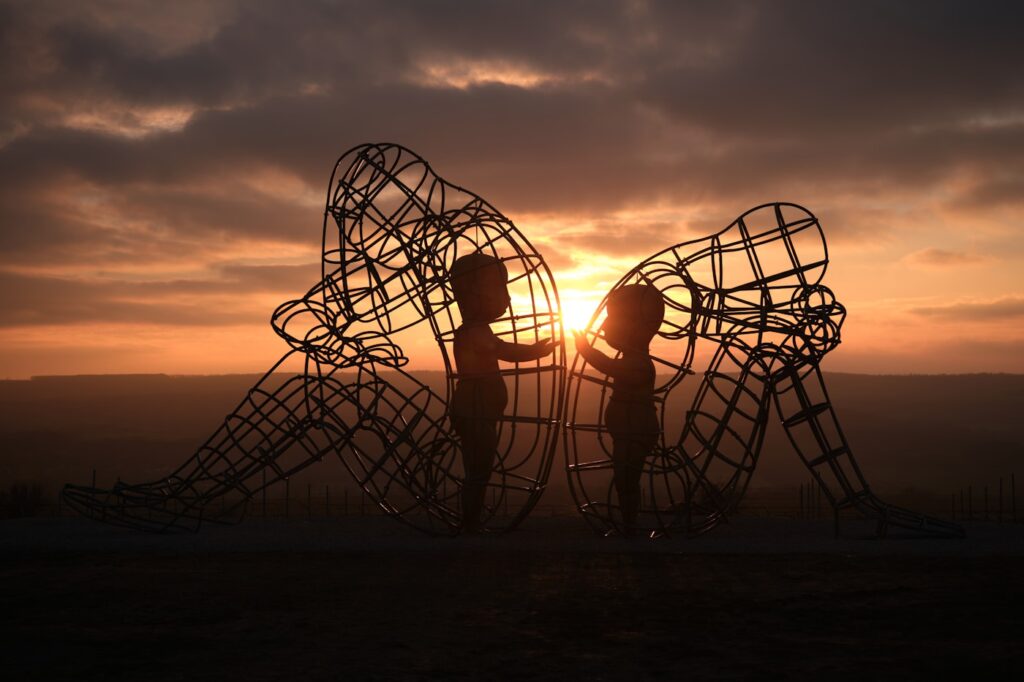 a couple of people that are standing in front of a sculpture
